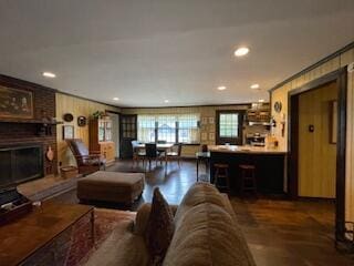living room with ornamental molding, a brick fireplace, recessed lighting, and wood finished floors