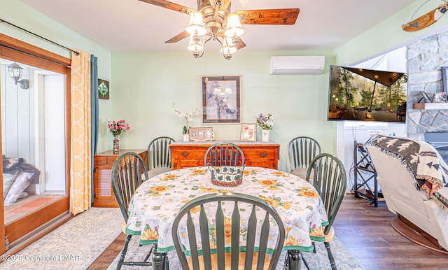 dining room with wood finished floors, ceiling fan, and a wall mounted AC