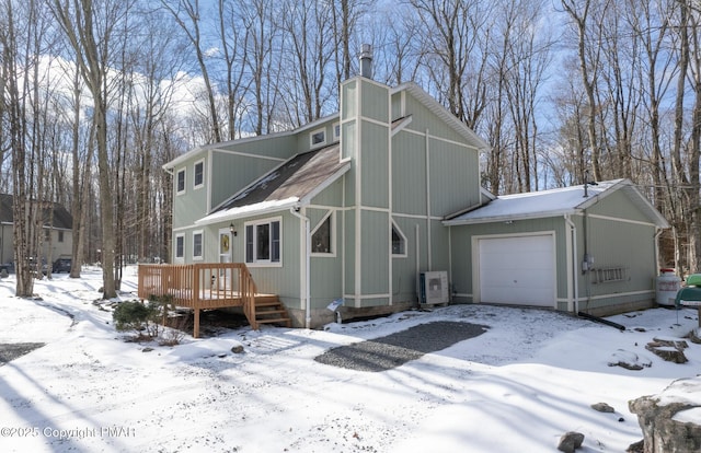 view of snow covered exterior featuring a shingled roof, a chimney, a garage, a deck, and ac unit