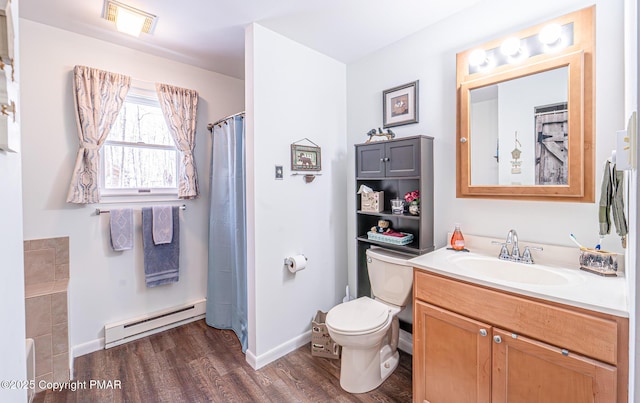 bathroom featuring vanity, wood finished floors, visible vents, a baseboard heating unit, and toilet