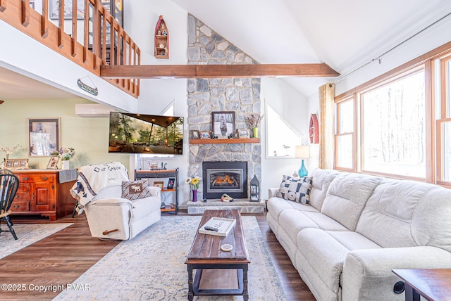 living room with a stone fireplace, high vaulted ceiling, and wood finished floors