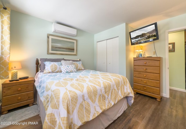 bedroom featuring a closet, a wall mounted air conditioner, baseboards, and wood finished floors