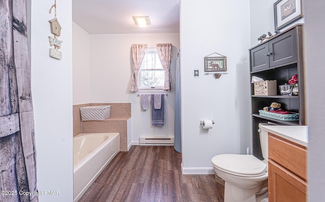 bathroom with baseboards, toilet, a garden tub, baseboard heating, and wood finished floors