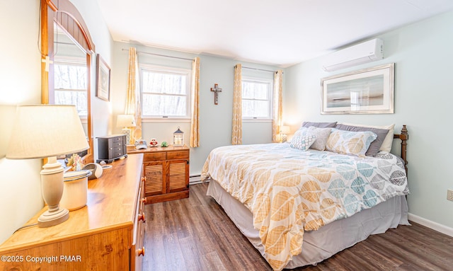 bedroom with a baseboard heating unit, baseboards, wood finished floors, and a wall unit AC