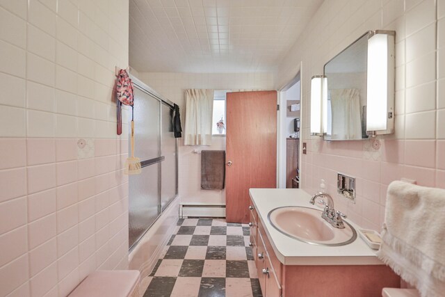 60 Maple Dr, Palmerton, PA 18071 - full bathroom with baseboard heating, combined bath / shower with glass door, vanity, tile walls, and tile patterned floors