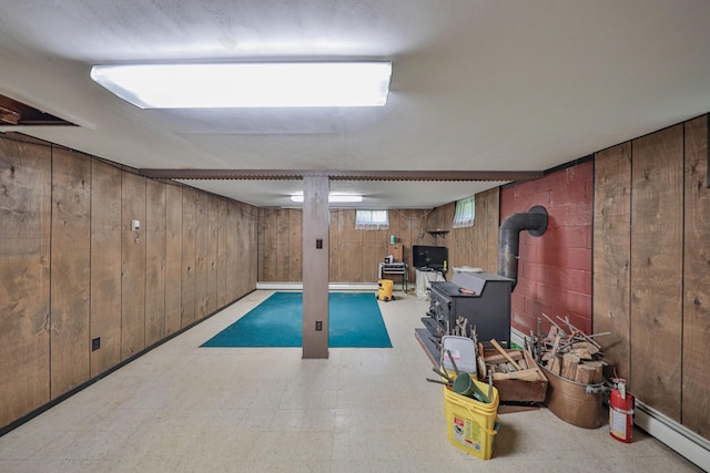 60 Maple Dr, Palmerton, PA 18071 - basement featuring tile patterned floors, wood walls, a wood stove, and baseboard heating