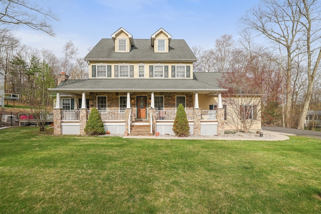 farmhouse with stone siding, covered porch, and a front yard