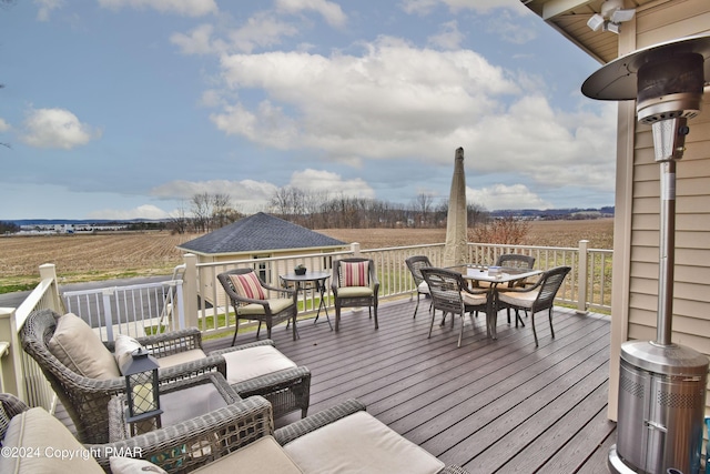 wooden terrace with outdoor dining area and a rural view