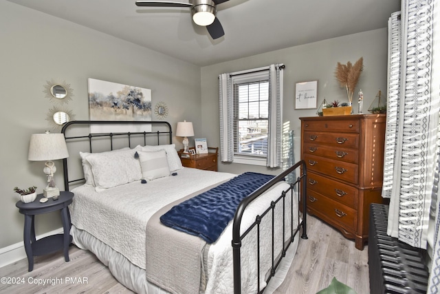 bedroom with light wood-type flooring, baseboards, and a ceiling fan