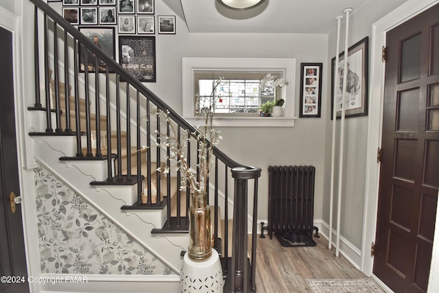 entryway featuring baseboards, radiator heating unit, and wood finished floors