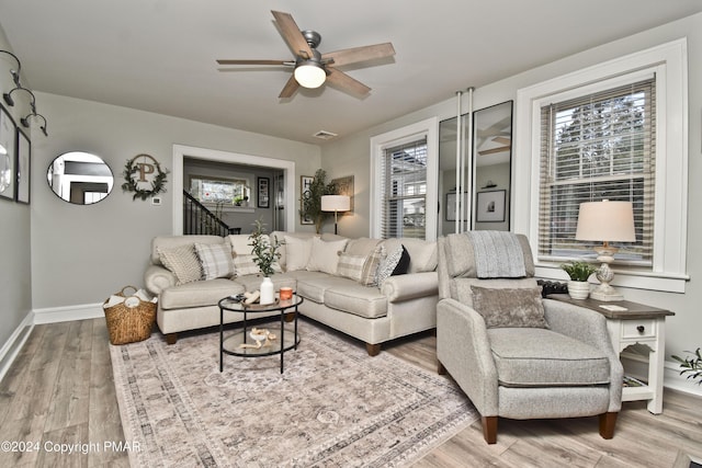 living room featuring plenty of natural light, wood finished floors, visible vents, and baseboards