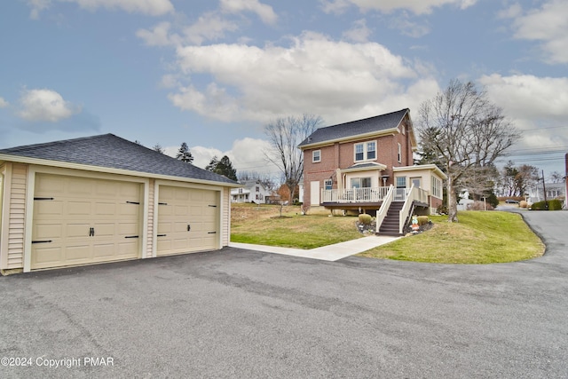 view of front of home featuring a shingled roof, stairs, an outdoor structure, a front yard, and brick siding