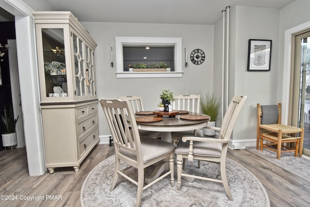 dining space with light wood-style flooring and baseboards