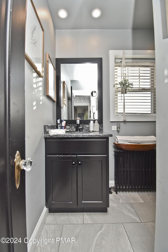 bathroom featuring double vanity, recessed lighting, a sink, and baseboards