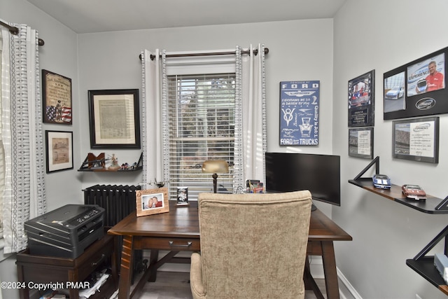 dining space with radiator, baseboards, and wood finished floors