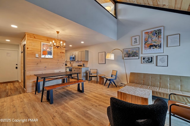 interior space featuring light wood-type flooring, a high ceiling, a notable chandelier, and recessed lighting