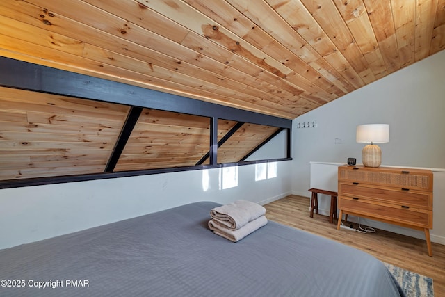 unfurnished bedroom with lofted ceiling with beams, wooden ceiling, baseboards, and wood finished floors