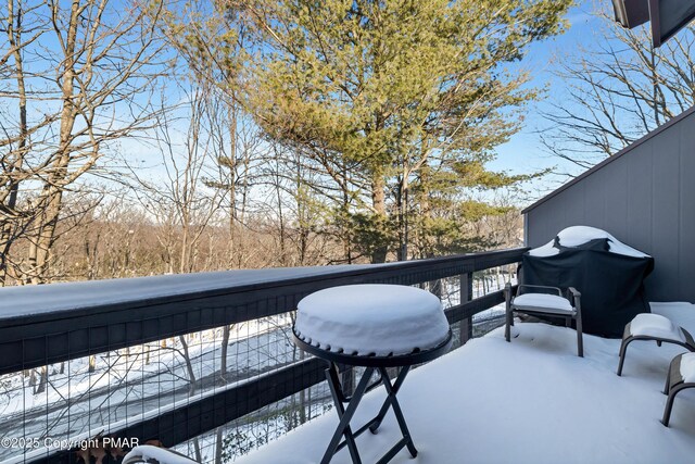 snow covered back of property featuring grilling area