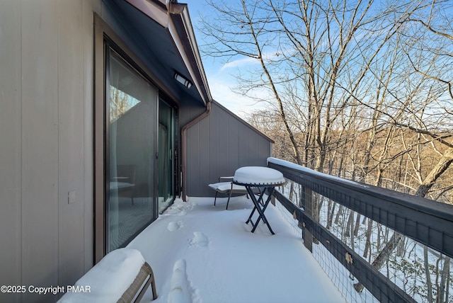 view of snow covered back of property