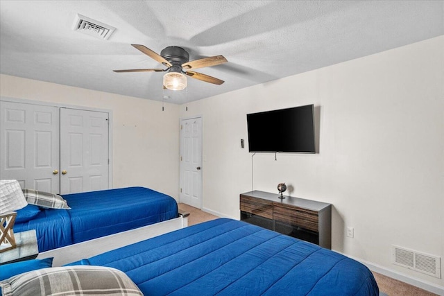 carpeted bedroom with visible vents, baseboards, ceiling fan, and a closet