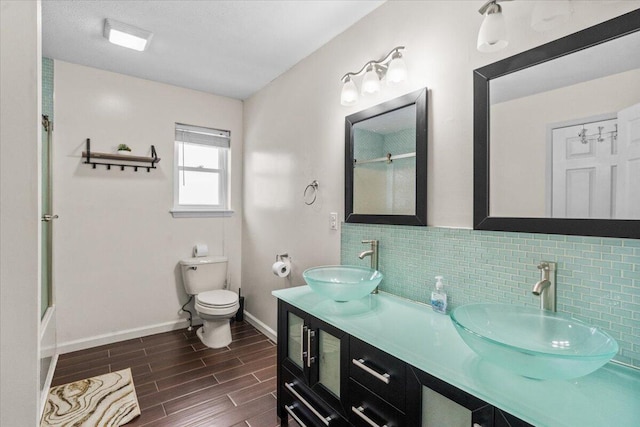 full bath with toilet, a sink, backsplash, and walk in shower