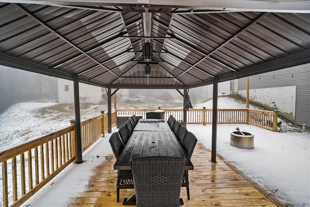 snow covered deck featuring outdoor dining space and a gazebo
