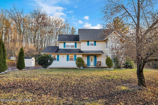 traditional-style house featuring an outbuilding, a storage shed, and a front lawn