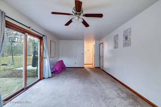 carpeted spare room with baseboards and a ceiling fan