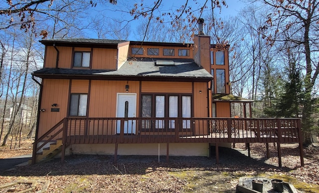 3221 Windermere Dr, Bushkill, PA 18324 - back of house featuring a shingled roof, a chimney, and a deck
