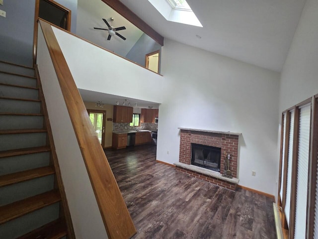 3221 Windermere Dr, Bushkill, PA 18324 - unfurnished living room with high vaulted ceiling, stairway, dark wood finished floors, a fireplace, and a skylight