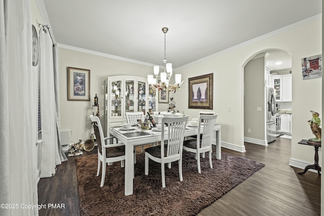 dining area with an inviting chandelier, crown molding, and dark wood-type flooring