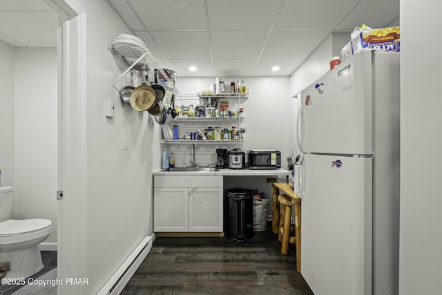 kitchen featuring sink, white cabinetry, a paneled ceiling, white refrigerator, and a baseboard radiator