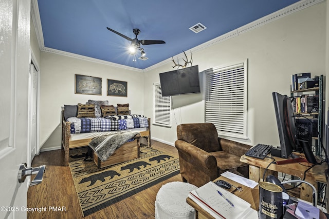 bedroom with crown molding, ceiling fan, wood-type flooring, and a closet