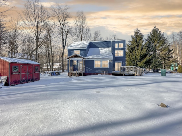 view of front of home featuring a wooden deck, a storage shed, and an outdoor structure