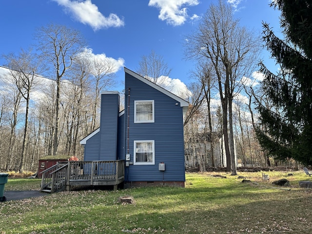 view of side of property with crawl space, a chimney, a wooden deck, and a yard