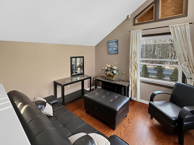 living room featuring baseboards, a textured ceiling, lofted ceiling, and wood finished floors