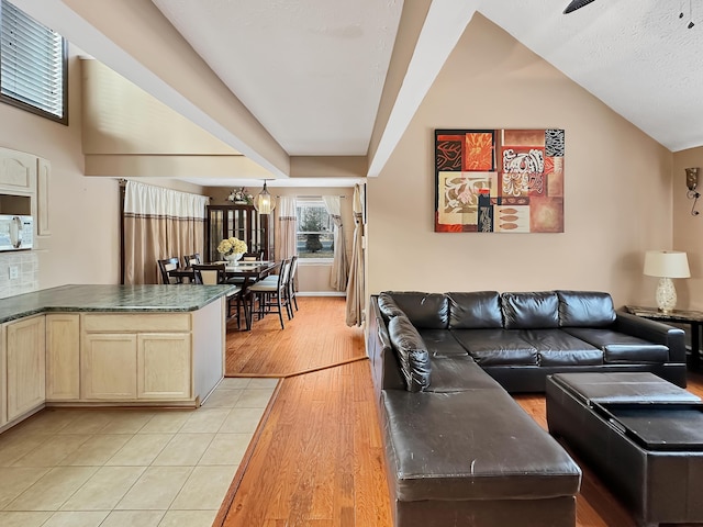 living area with light wood-type flooring and lofted ceiling