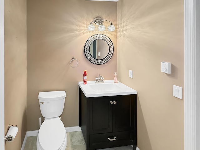 half bathroom featuring tile patterned floors, toilet, vanity, and baseboards