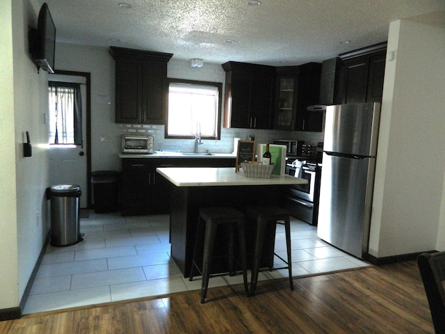 7086 Boulder Ct, Tobyhanna, PA 18466 - kitchen featuring appliances with stainless steel finishes, a sink, dark cabinetry, baseboards, and a textured ceiling