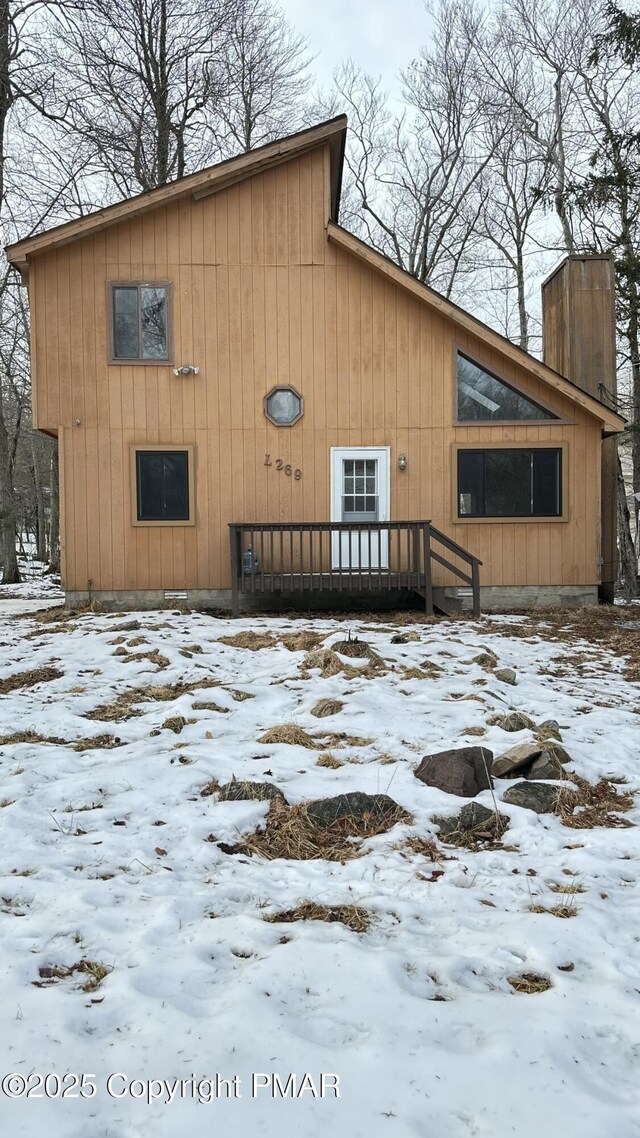 view of snow covered rear of property