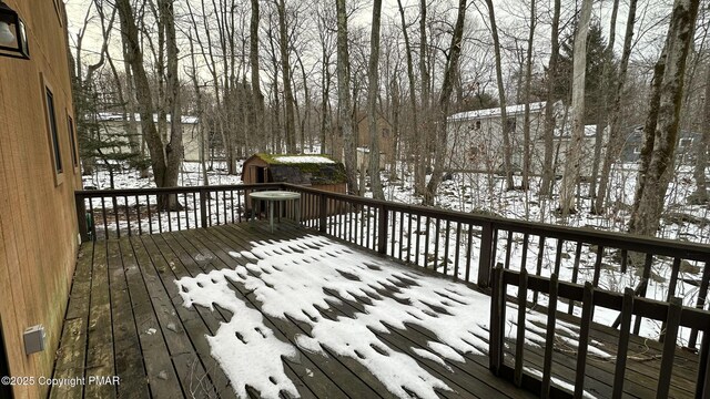 snow covered deck with a storage shed