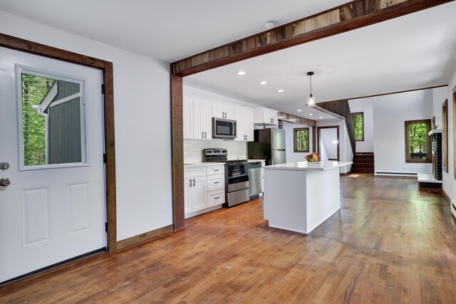 8210 Pine Grove Dr, East Stroudsburg, PA 18301 - kitchen with appliances with stainless steel finishes, light wood-type flooring, white cabinets, light countertops, and tasteful backsplash