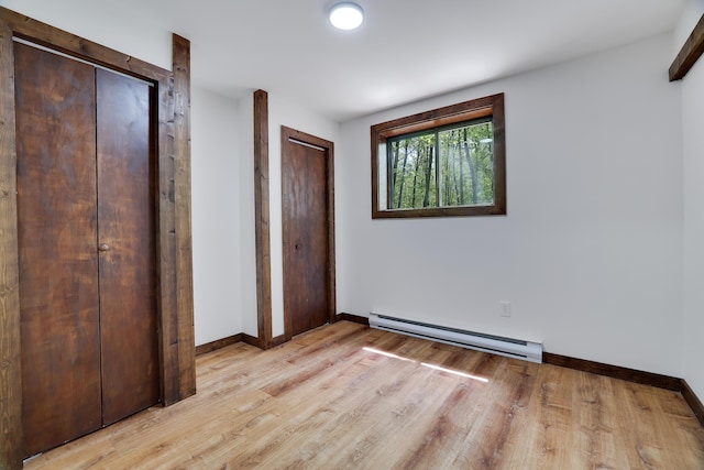 8210 Pine Grove Dr, East Stroudsburg, PA 18301 - unfurnished bedroom featuring a baseboard heating unit, light wood-type flooring, and baseboards