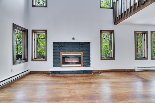 8210 Pine Grove Dr, East Stroudsburg, PA 18301 - unfurnished living room with a baseboard radiator, a high ceiling, wood finished floors, and healthy amount of natural light