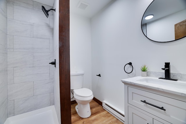 8210 Pine Grove Dr, East Stroudsburg, PA 18301 - full bathroom featuring a baseboard heating unit, toilet, vanity, a tile shower, and wood finished floors