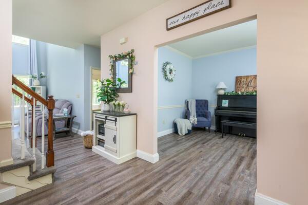 corridor featuring wood finished floors, baseboards, and stairs