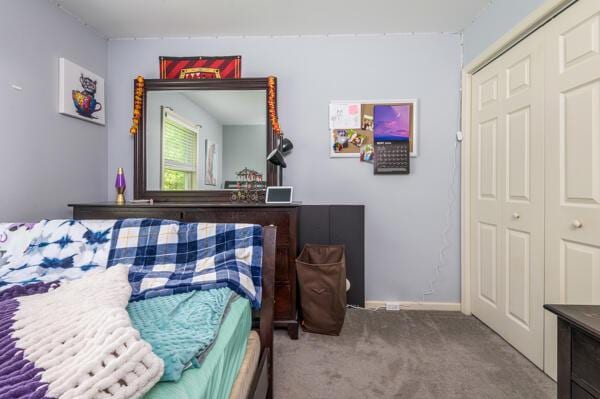 carpeted bedroom featuring a closet and baseboards
