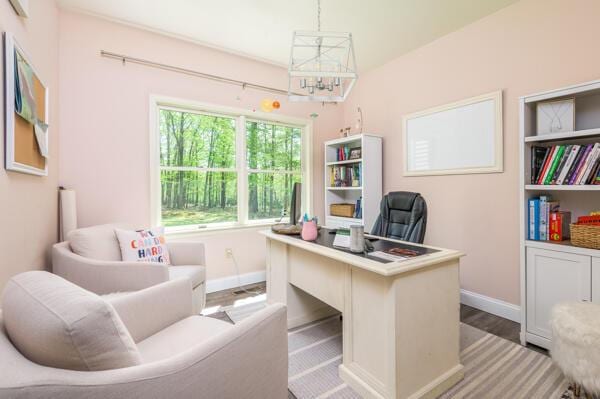 office area featuring a chandelier, baseboards, and wood finished floors