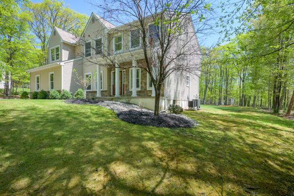 view of front facade with a front lawn and central AC unit