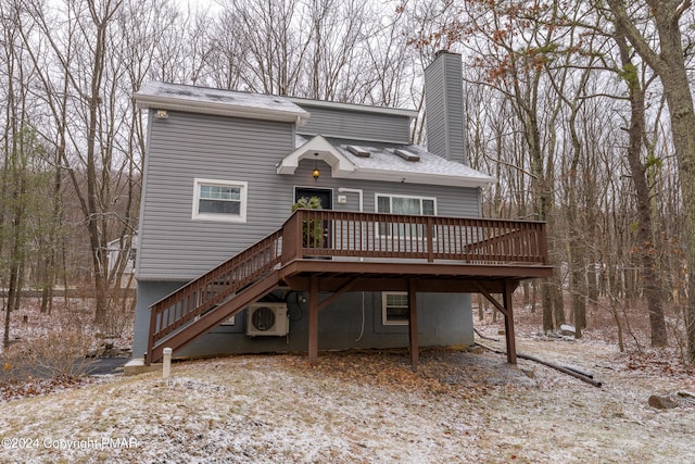 view of front of home featuring ac unit, roof with shingles, a chimney, stairway, and a wooden deck